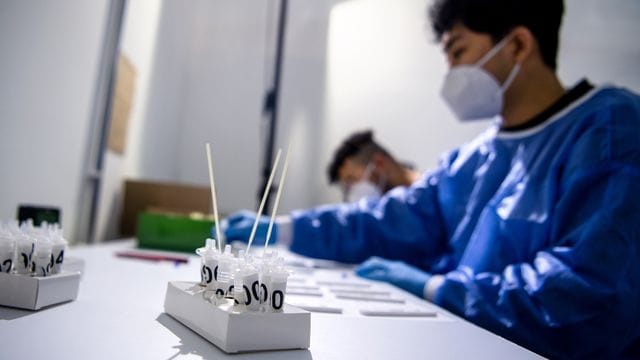Ein Mitarbeiter eines Testzentrums in Bremen wertet Corona-Schnelltests aus.