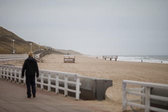 Ein Spaziergänger blickt auf das Meer: An diesem Donnerstag ist nur wenig los am Strand von Westerland.