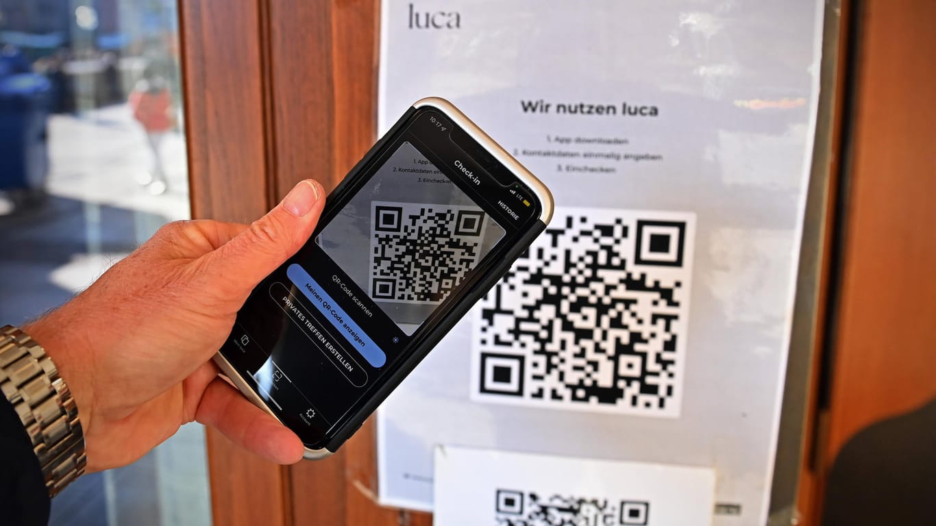 Eine Person checkt mit der Luca-App vor einem Restaurant ein (Archivbild): Bremen will zukünftig auf die App verzichten.