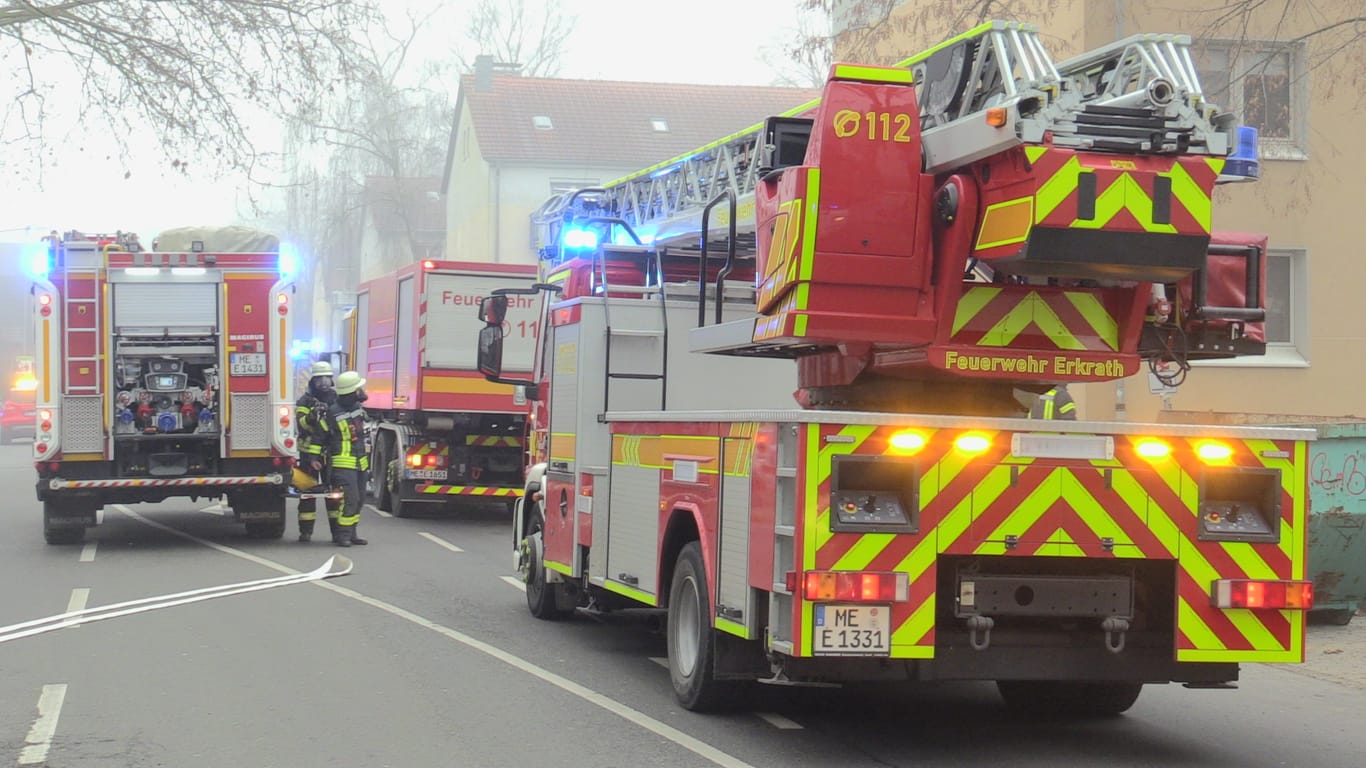Feuerwehrfahrzeuge stehen während des Einsatzes auf der Straße: In der brennenden Wohnung fanden die Rettungskräfte einen toten Mann.