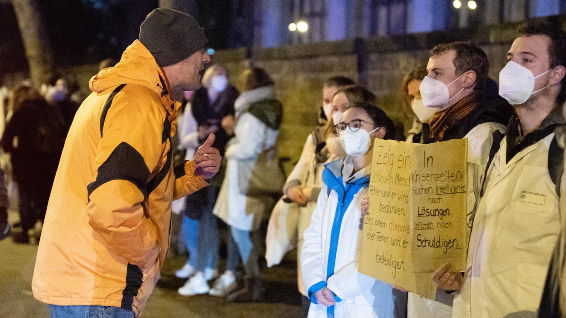 Ein Teilnehmer einer Corona-Demo steht vor Gegendemonstranten: Für die Aktion ernteten die Studierenden viel Zuspruch.