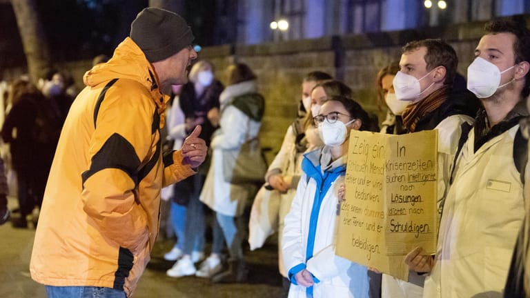 Ein Teilnehmer einer Corona-Demo steht vor Gegendemonstranten: Für die Aktion ernteten die Studierenden viel Zuspruch.