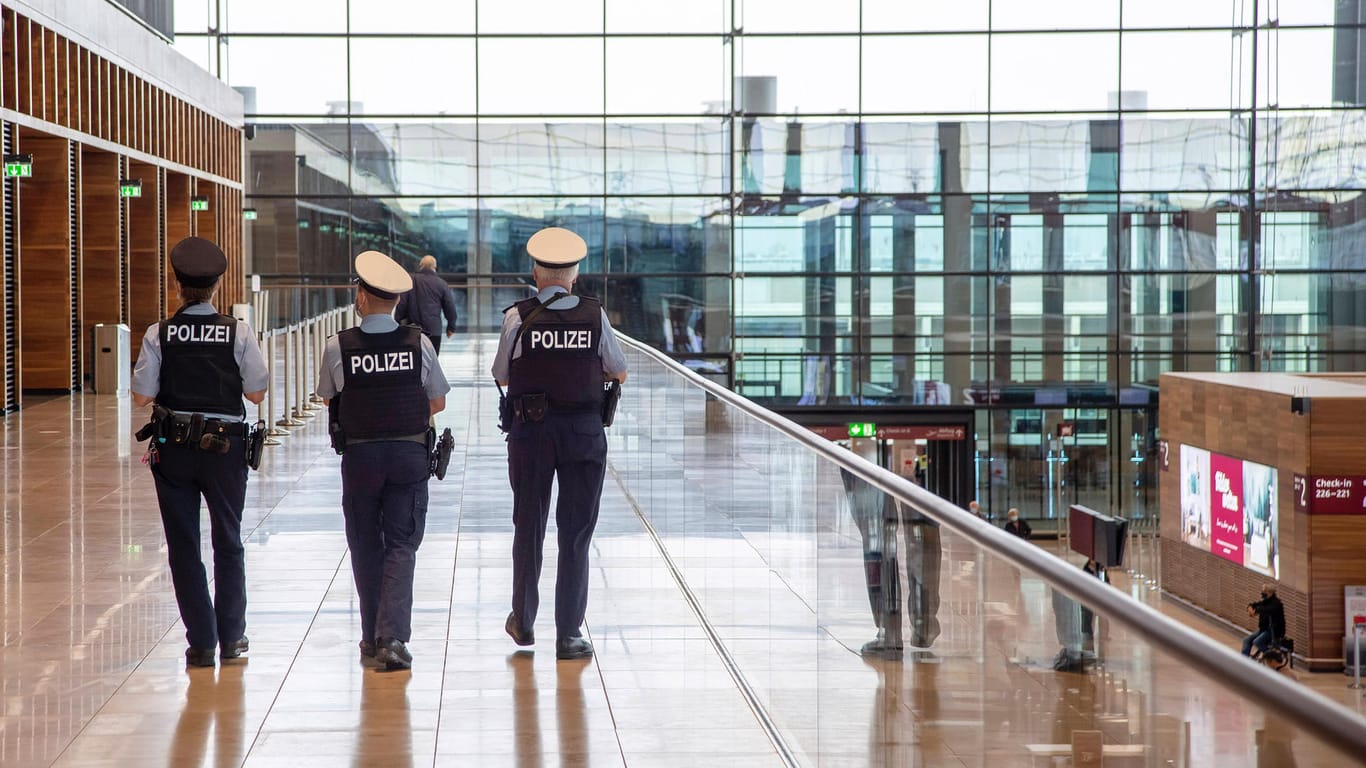 Polizeibeamte laufen durch den Flughafen BER (Archivbild): Die Fahndung nach dem Tatverdächtigen endete an der Ausreisekontrolle.