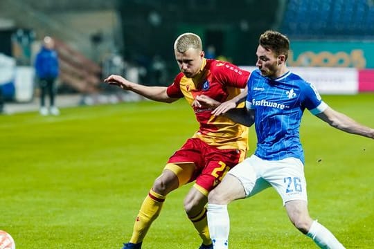 Der Karlsruher Marco Thiede (l) im Zweikampf mit Darmstadt-Profi Matthias Bader.