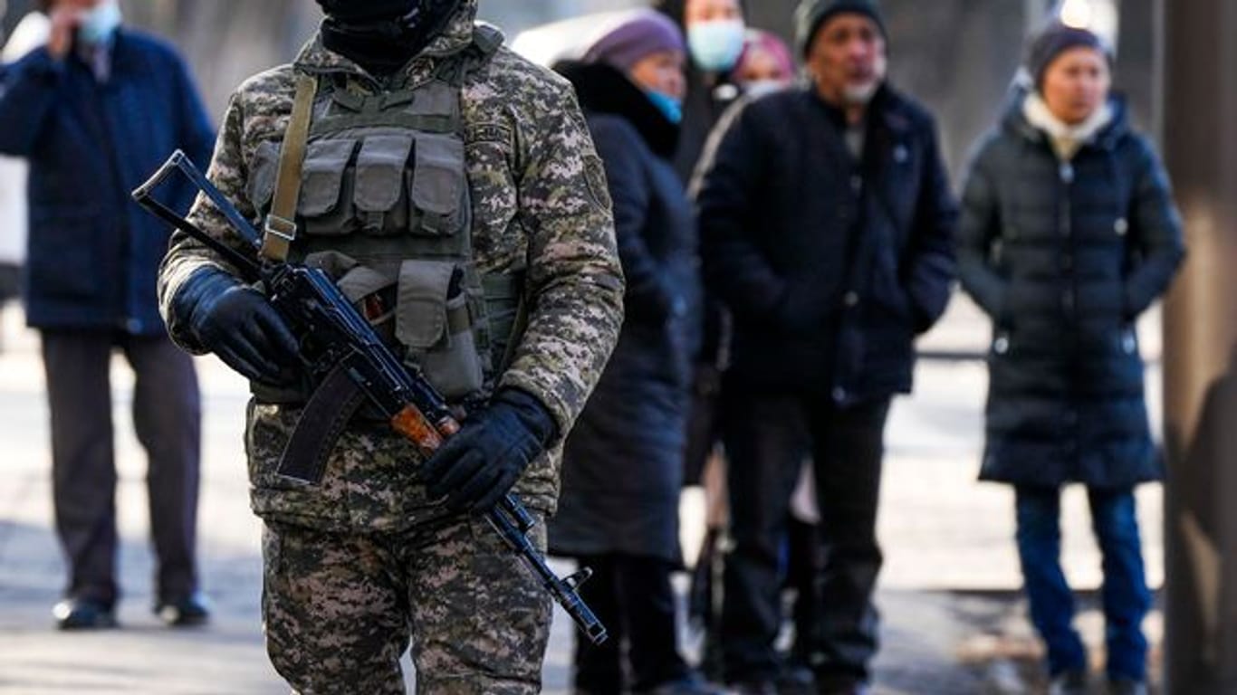 Ein kasachischer Soldat patrouilliert in Almaty nahe einer Polizeistation.