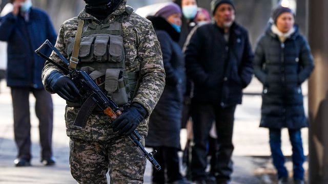 Ein kasachischer Soldat patrouilliert in Almaty nahe einer Polizeistation.