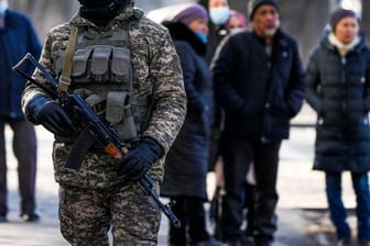 Ein kasachischer Soldat patrouilliert in Almaty nahe einer Polizeistation.