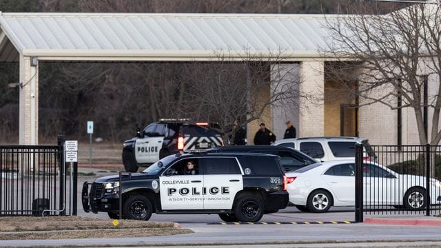Polizeifahrzeuge stehen während der Geiselnahme auf der Zufahrt der Synagoge in Colleyville. Polizeifahrzeuge stehen während der Geiselnahme auf der Zufahrt der Synagoge in Colleyville.