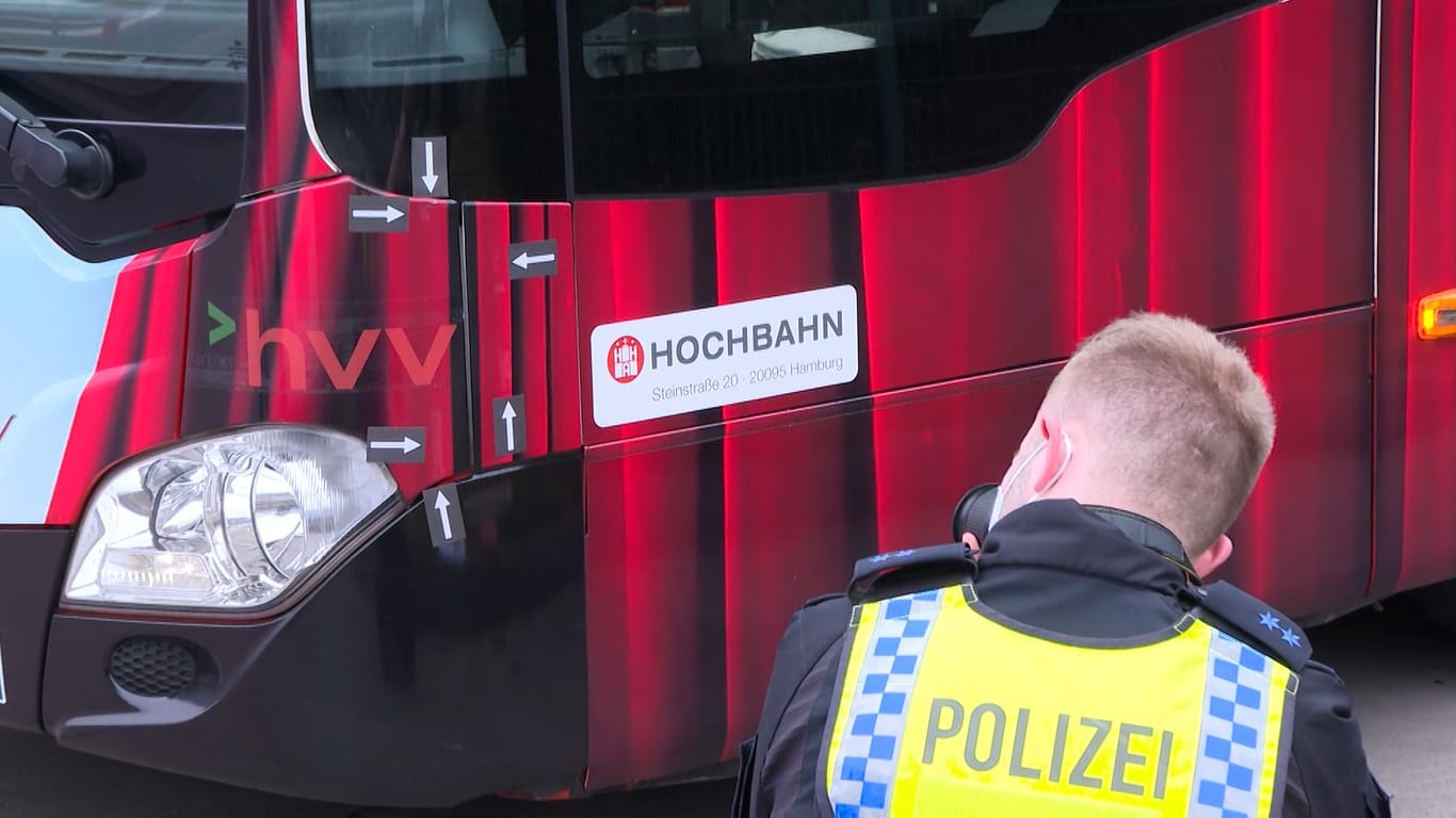 Ein Polizist fotografiert die Stelle des Busses, die den Feuerwehrmann getroffen hat: Der Schwerverletzte musste zur OP ins Krankenhaus.