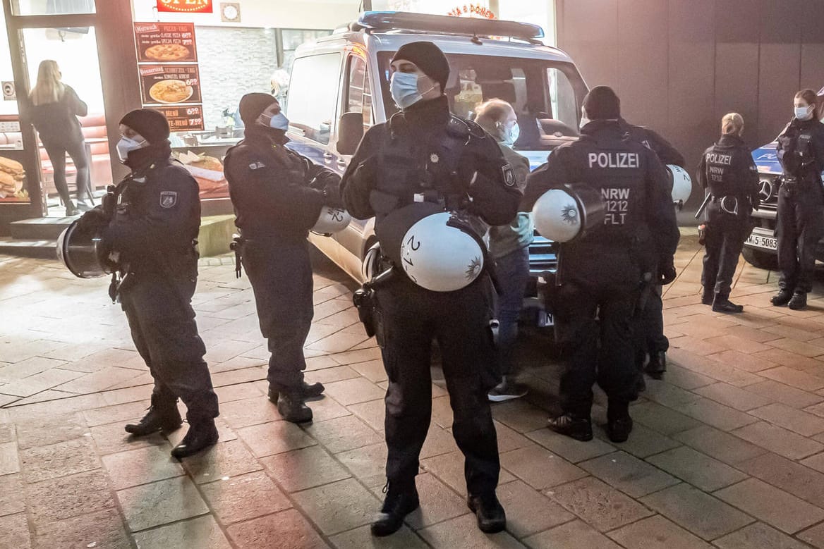 Polizisten vor einem Laden in Lüdenscheid während einer Corona-Demonstration: Gewaltbereite Impfgegner bereiten auch dem Handel zunehmend Probleme. Polizisten vor einem Laden in Lüdenscheid während einer Corona-Demonstration: Gewaltbereite Impfgegner bereiten auch dem Handel zunehmend Probleme.