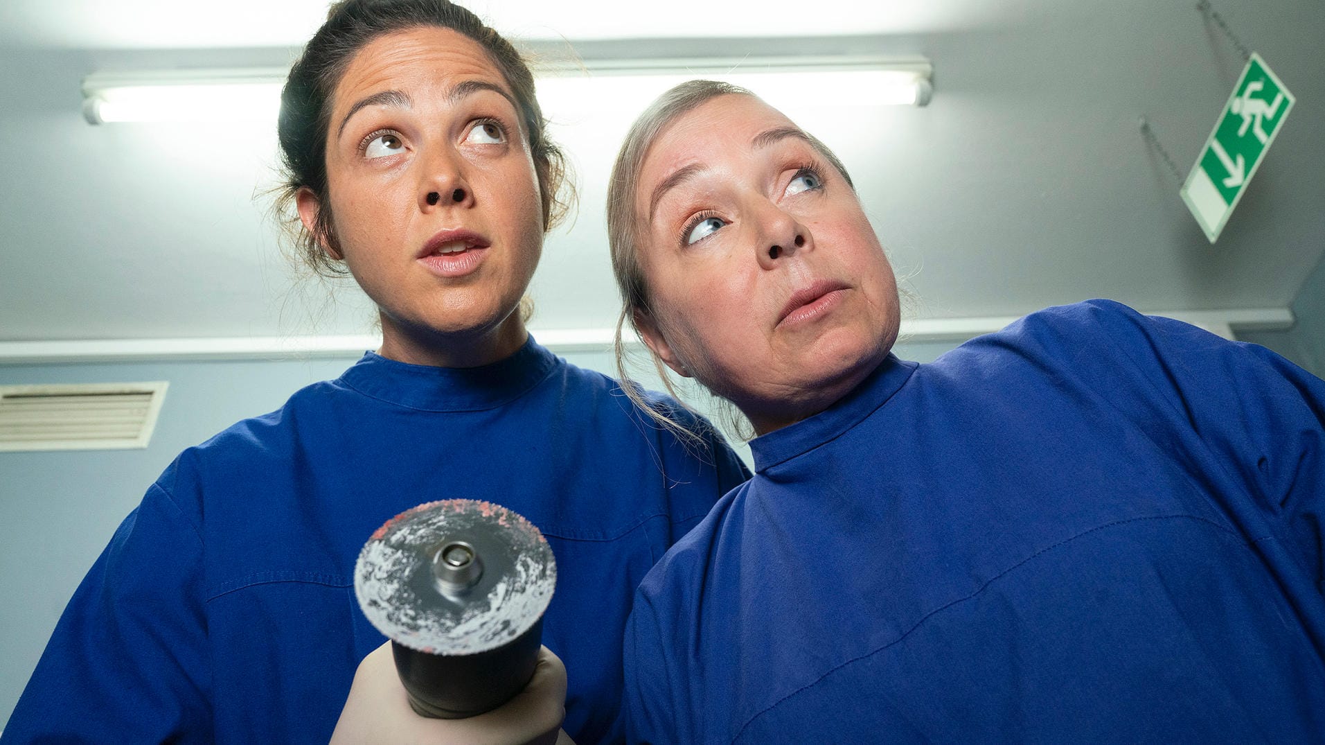 Vivian Peters (Judith Goldberg) und Silke Haller (ChrisTine Urspruch) untersuchen Hartnacks Leiche während Boerne schläft.