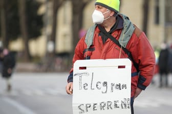 Ein Demonstrant hält ein Schild mit dem Text "Telegram sperren" hoch (Archivbild): Das BKA will offenbar jetzt den Druck auf den Messengerdienst erhöhen.