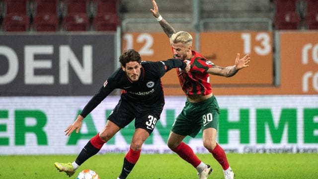 Goncalo Paciencia von Eintracht Frankfurt (l) schirmt den Ball gegen Augsburgs Niklas Dorsch ab. Goncalo Paciencia von Eintracht Frankfurt (l) schirmt den Ball gegen Augsburgs Niklas Dorsch ab.