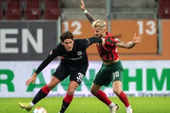 Goncalo Paciencia von Eintracht Frankfurt (l) schirmt den Ball gegen Augsburgs Niklas Dorsch ab.