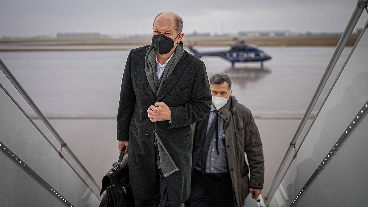 Bundeskanzler Olaf Scholz (SPD, l) am Flughafen BER auf dem Weg nach Madrid.