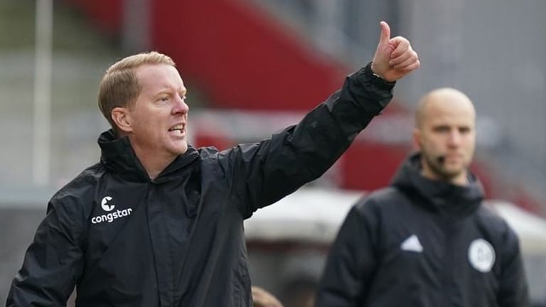 St. Paulis Trainer Timo Schultz steht am Spielfeldrand und hebt den Daumen (Archivbild): Die Gegner sollten "gestresst" werden.