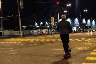 Ein Mann fährt nachts mit einem E-Scooter (Symbolbild): Politiker fordern strengere Regeln für den Gebrauch der Roller.