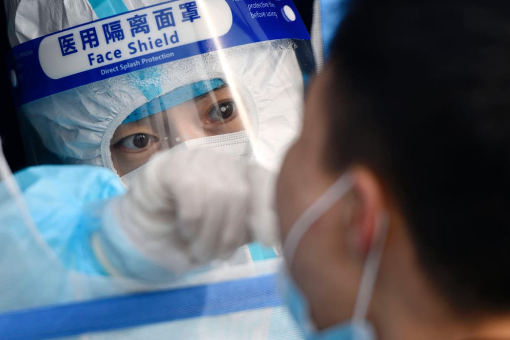 Helferin nimmt einen Corona-Abstrich bei einem Mann in Tianjin: In der Nachbarstadt von Peking wurde der erste Omikron-Fall in China registriert.