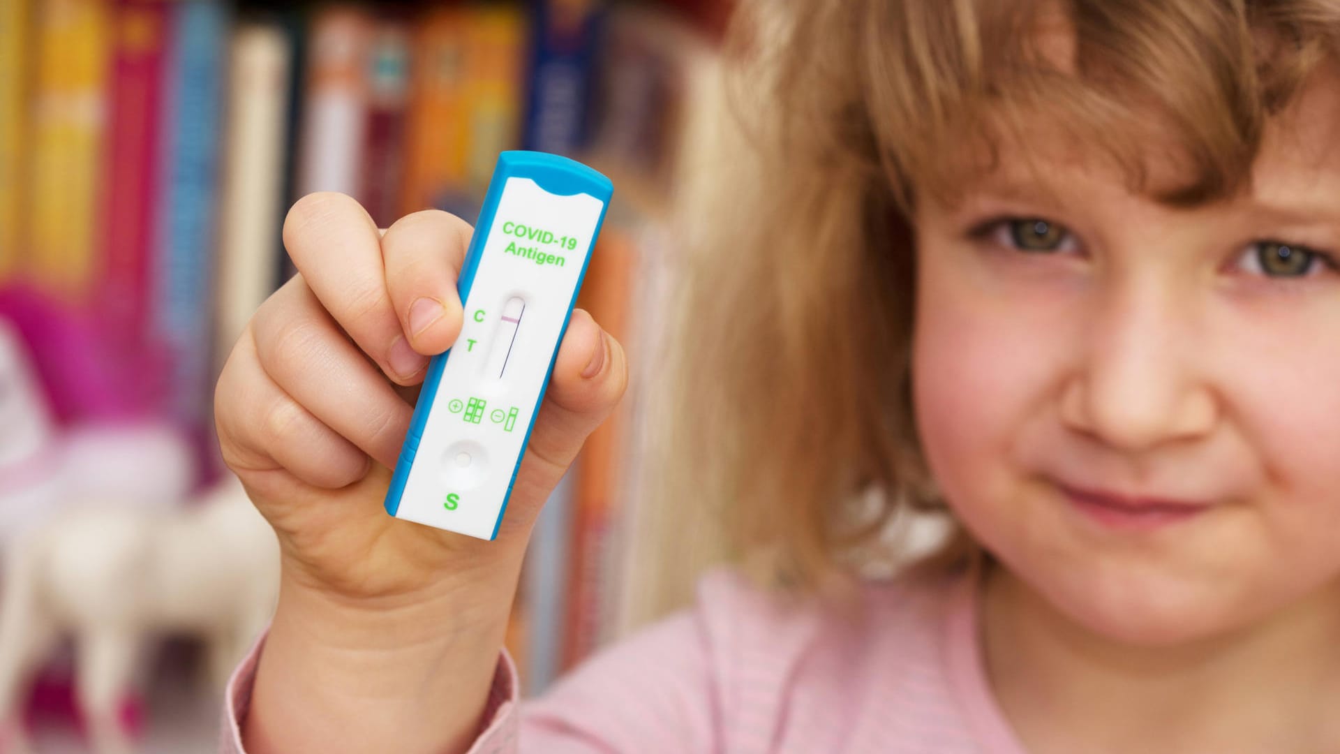 Ein Kind hält einen Corona-Test in der Hand (Symbolbild): Etwa an Montagen soll ein Test für Kita-Kinder verpflichtend sein. Ein Kind hält einen Corona-Test in der Hand (Symbolbild): Etwa an Montagen soll ein Test für Kita-Kinder verpflichtend sein.