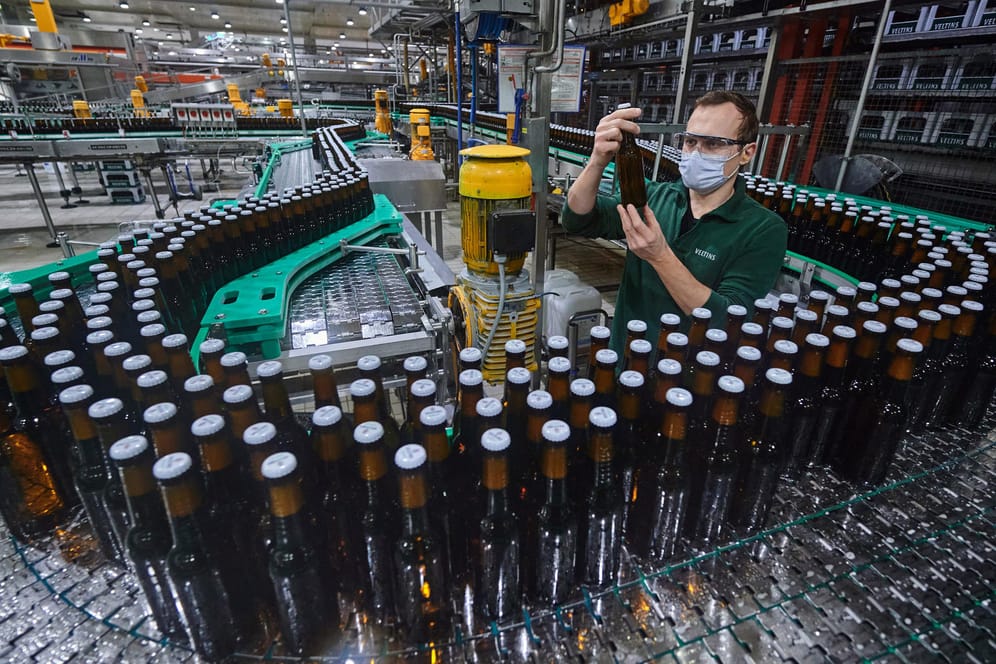 Ein Mitarbeiter kontrolliert die Flaschenabfüllung: Im Vergleich zum Vorjahr konnte sich der Bierabsatz erholen.