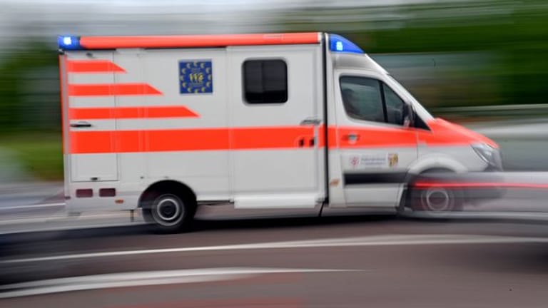 Ein Krankenwagen fährt mit Blaulicht durch die Innenstadt