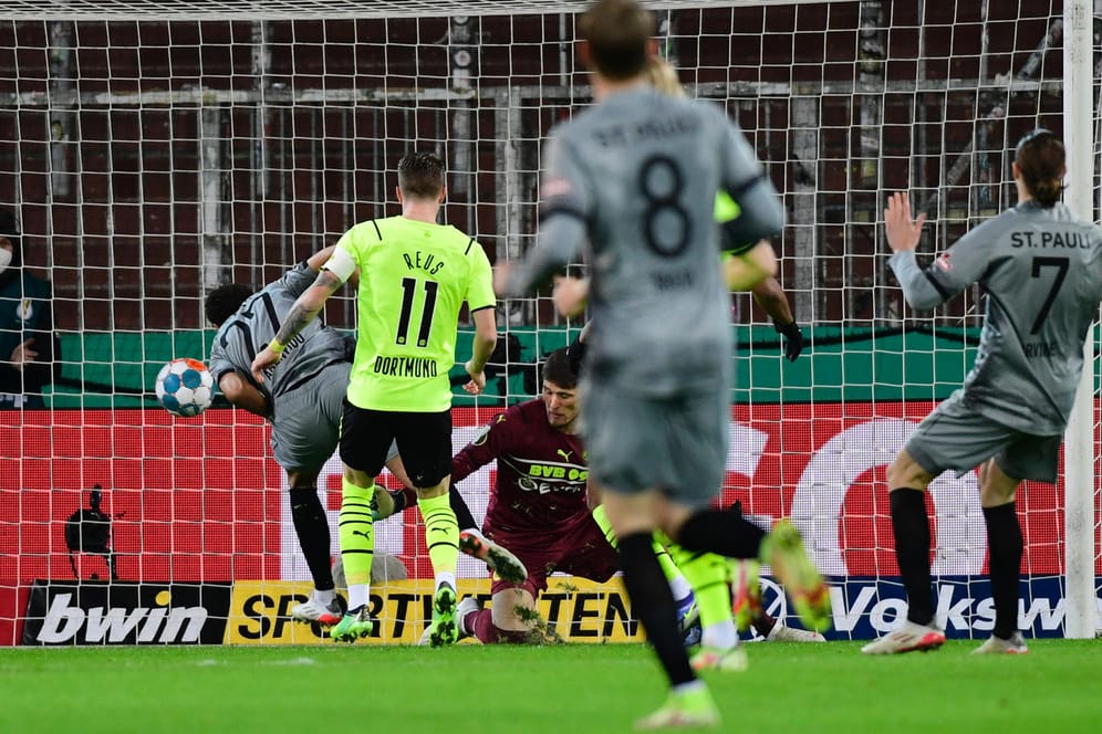 Das 1:0: St. Paulis Amenyido (li.) trifft gegen BVB-Keeper Kobel.