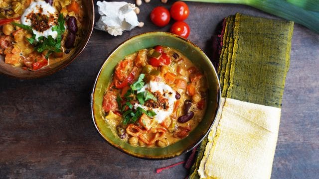 Der marokkanische Eintopf wird mit einem Klecks Kokosjoghurt, Petersilienblättchen und einer eigenen Gewürzkreation getoppt.