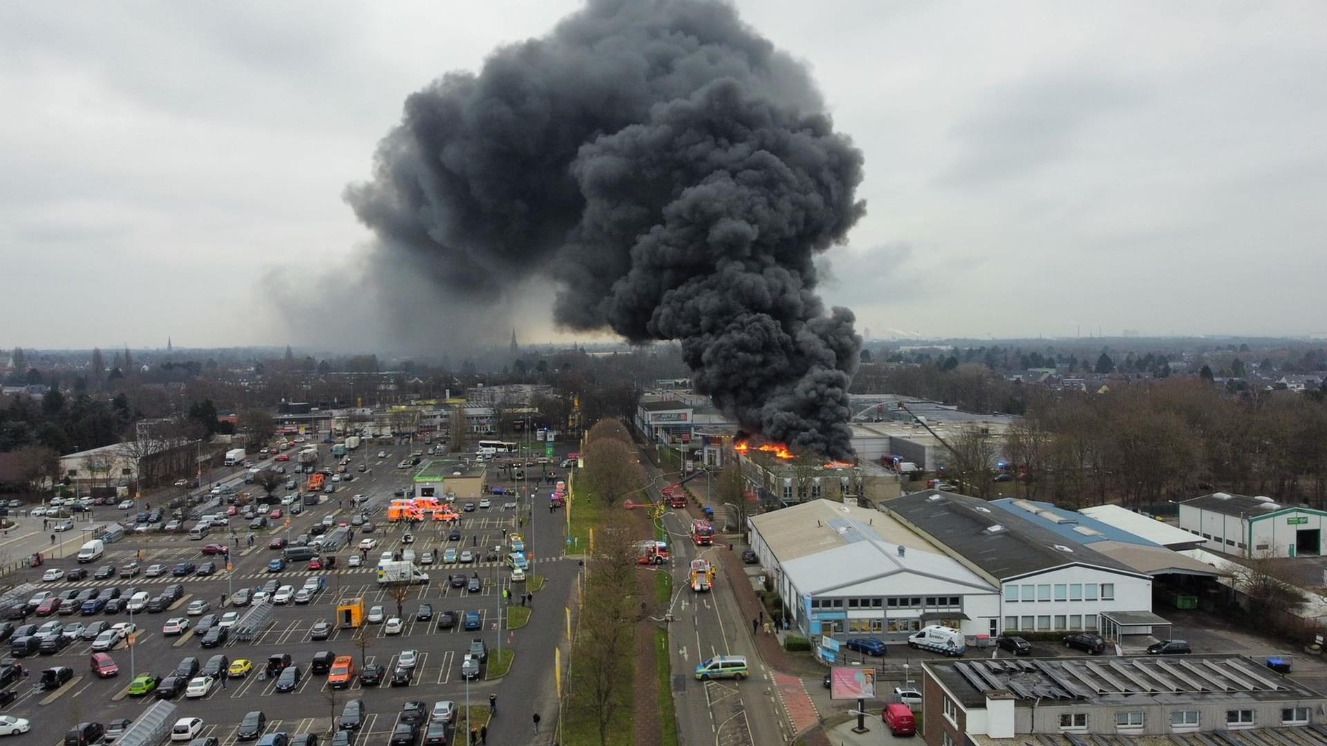 Die Rauchwolke steigt meterhoch in den Himmel: Der Brand im Gewerbegebiet könnte zu "gesundheitlichen Beeinträchtigungen" führen.