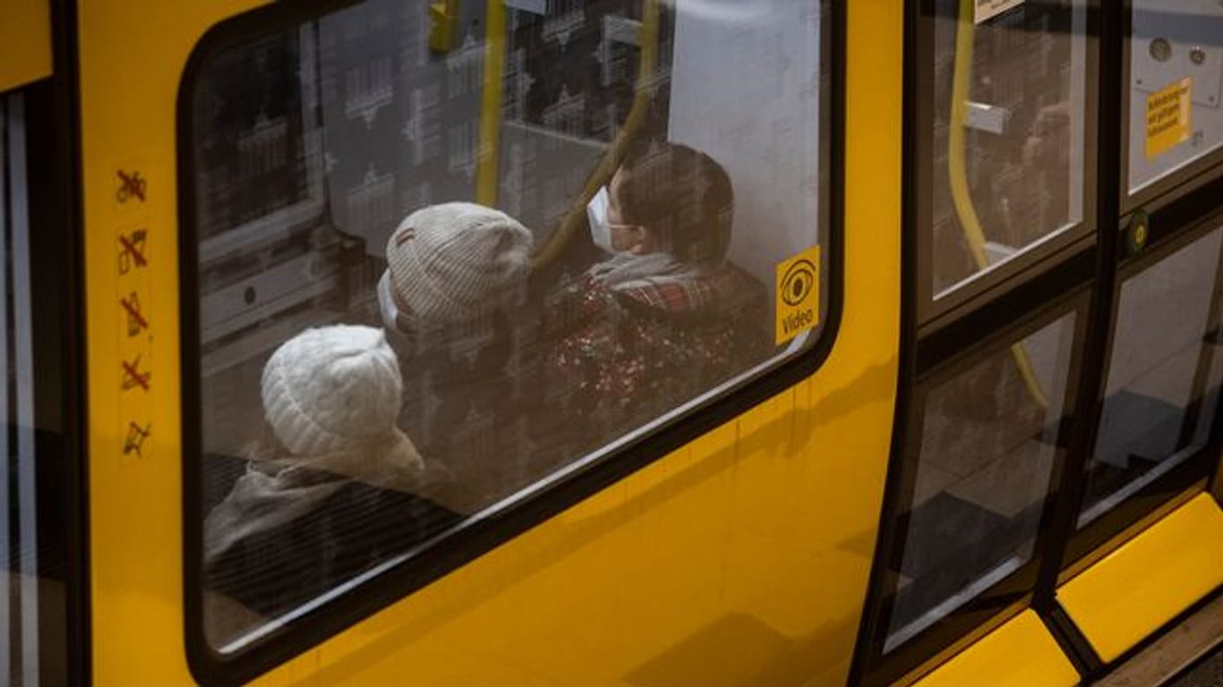 Fahrgäste sitzen mit FFP2-Masken in einer U-Bahn