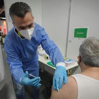 Ein Mitarbeiter im Gesundheitswesen impft einen Mann gegen Corona (Archivbild): Im Kampf gegen das Coronavirus gilt in Österreich bald eine Impfpflicht.
