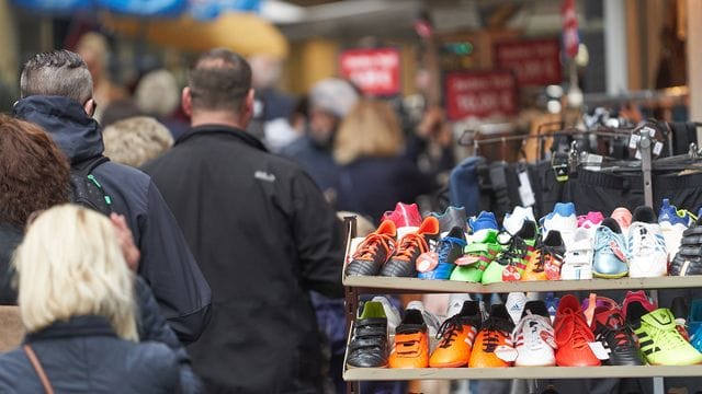 Passanten gehen an einem Schuhgeschäft vorbei