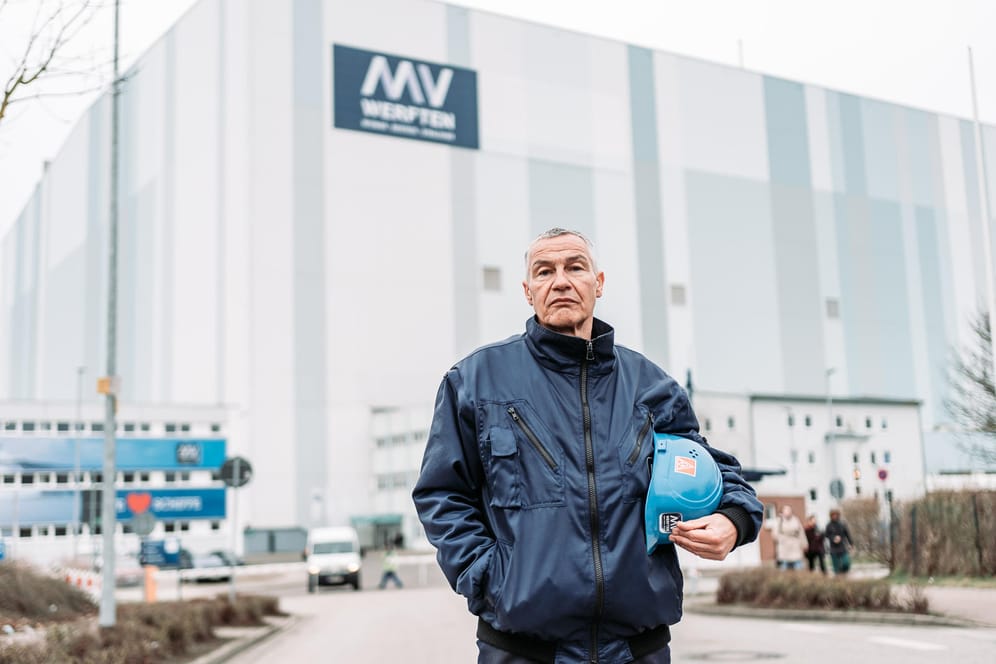 Betriebsrat Folko Manthey vor dem MV-Werften-Standort Wismar: In der Halle hinter ihm liegt die "Global Dream One", aber aktuell ist unklar, ob sie fertiggebaut werden kann.