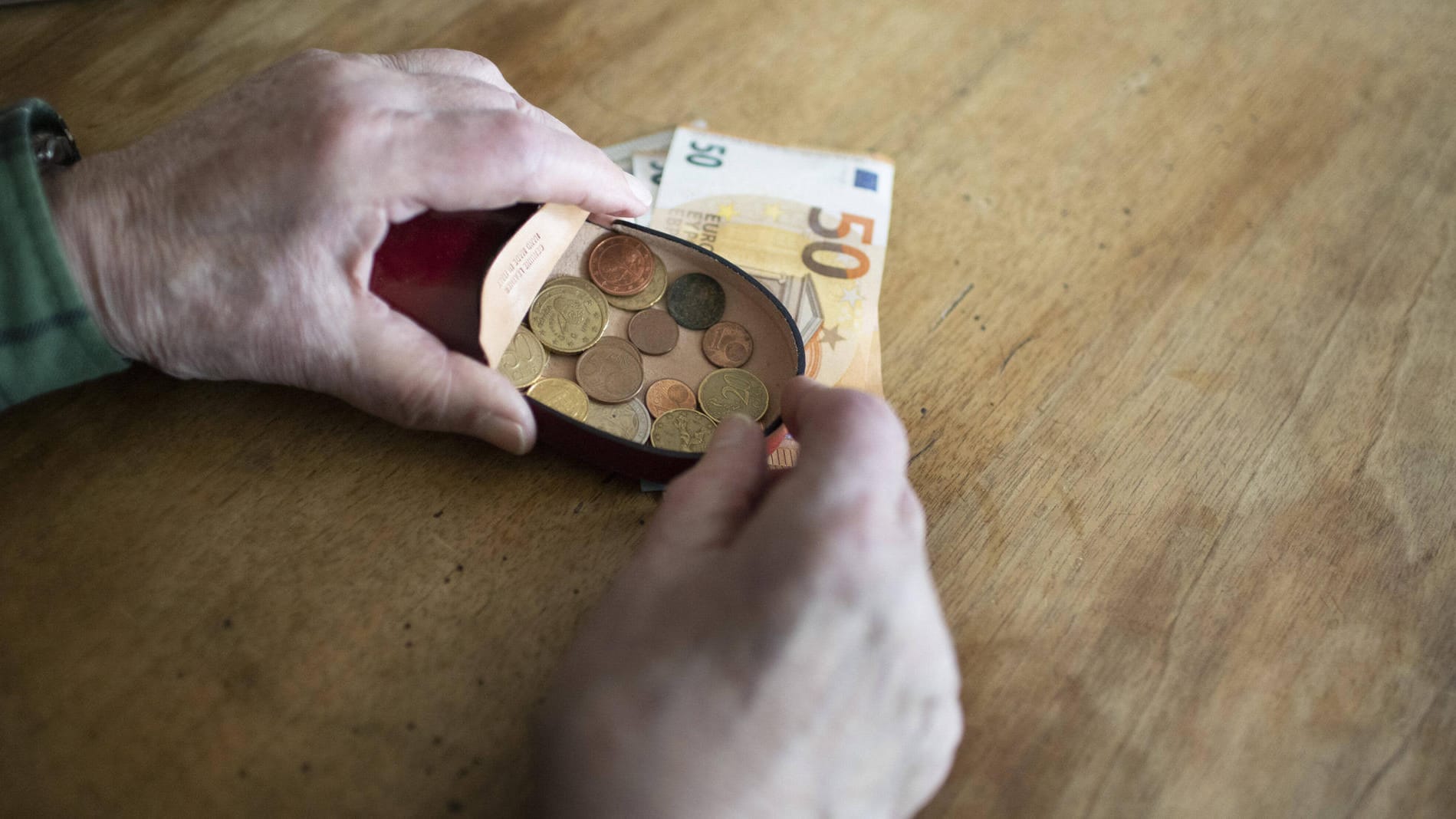 Rentner hält Geld in der Hand (Symbolbild): Besonders viele kleine Renten werden im Westen und an Frauen gezahlt.