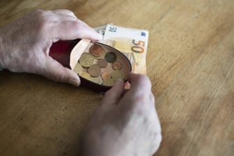 Rentner hält Geld in der Hand (Symbolbild): Besonders viele kleine Renten werden im Westen und an Frauen gezahlt.
