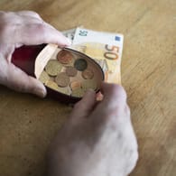 Rentner hält Geld in der Hand (Symbolbild): Besonders viele kleine Renten werden im Westen und an Frauen gezahlt.