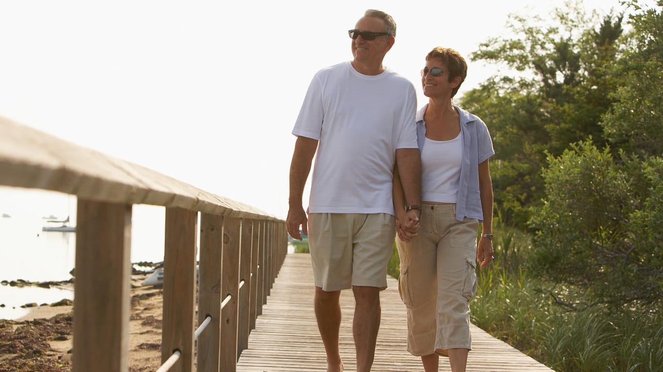 Rentner beim Strand-Spaziergang (Symbolbild): Versicherungszeiten im Ausland können für die Mindestversicherungszeit für eine Rente zusammengerechnet werden.