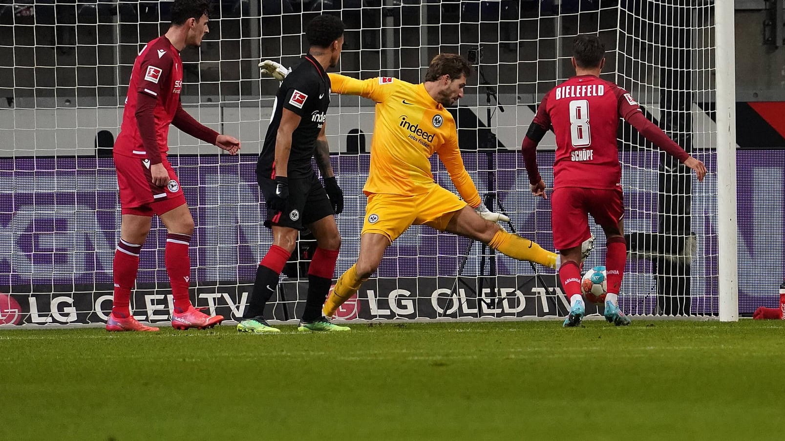 Der Ball von Bielefelds Schöpf fliegt aufs Tor, Frankfurts Torwart Trapp (r.) ist chancenlos.