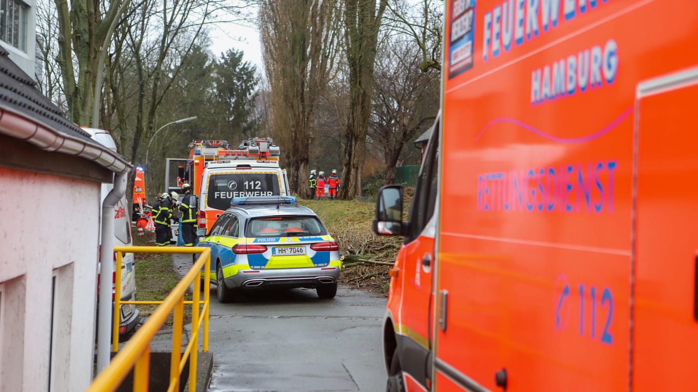 Mehrere Einsatzfahrzeuge von Polizei und Feuerwehr stehen neben einem Wohnhaus: Das Feuer war in der Küche des Mannes ausgebrochen.