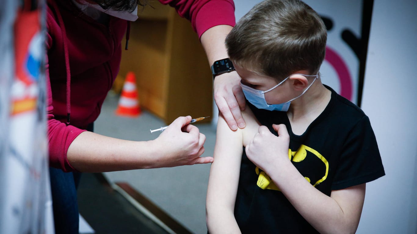 Ein Junge wird mit gegen Corona geimpft (Archivbild): Experten raten zu einer höheren Impfquote in der Gesamtbevölkerung.