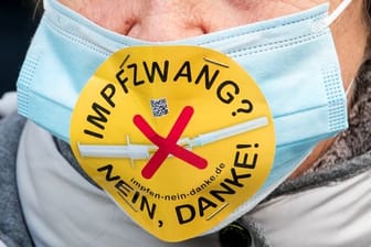 Eine Teilnehmerin einer Demonstration in Hamburg mit einem Mundschutz und der Aufschrift "Impfzwang? Nein, danke!".