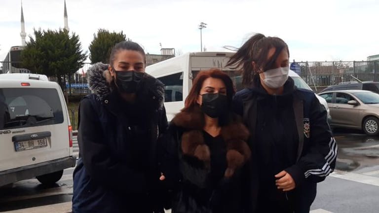 Polizeibeamte eskortieren Sedef Kabas, eine bekannte türkische Journalistin, vor ihrem Auftritt vor Gericht in Istanbul.