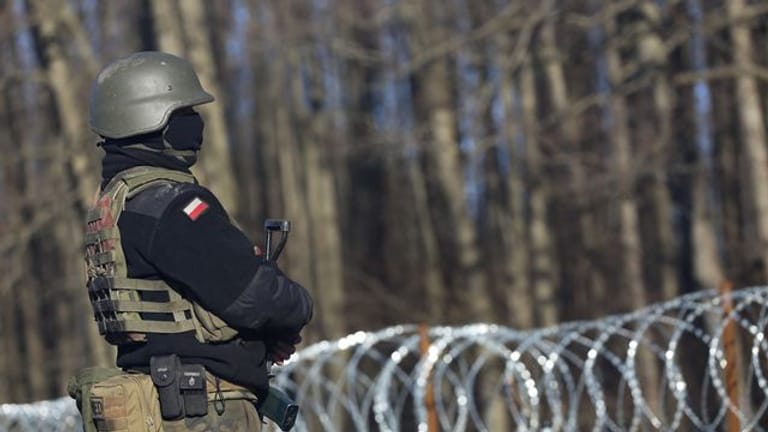 Ein bewaffneter polnischer Soldat bewacht in der Nähe des Ortes Usnarz Gorny die EU-Außengrenze zu Belarus.