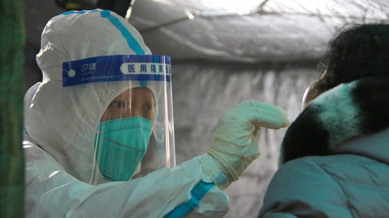 Peking: Eine Medizinerin testet eine Person aus der Bevölkerung auf das Coronavirus.