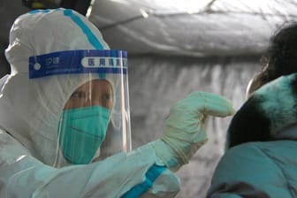 Peking: Eine Medizinerin testet eine Person aus der Bevölkerung auf das Coronavirus.