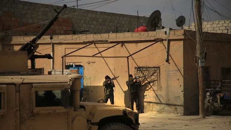 Kämpfer der kurdisch geführten Syrischen Demokratischen Kräfte mit Gewehren in der Nähe des Gweiran-Gefängnisses.