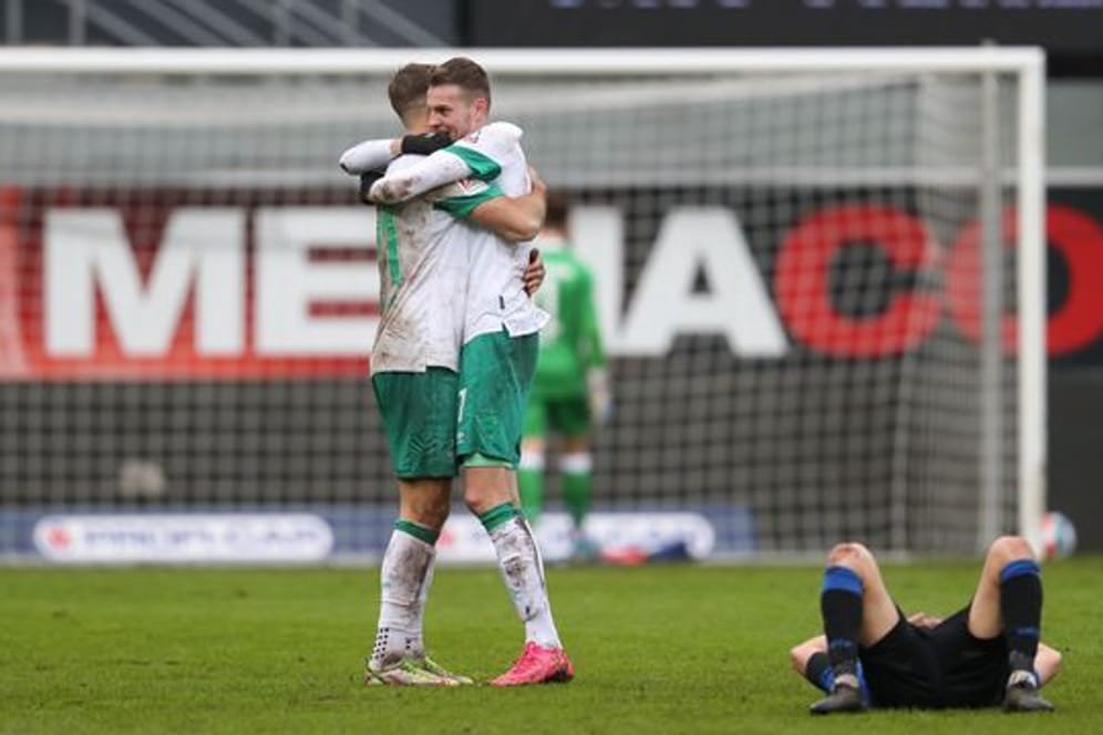 Marvin Ducksch (M) und Niclas Füllkrug (l) feiern das Ende eines wilden Spiels und den Sieg über Paderborn.