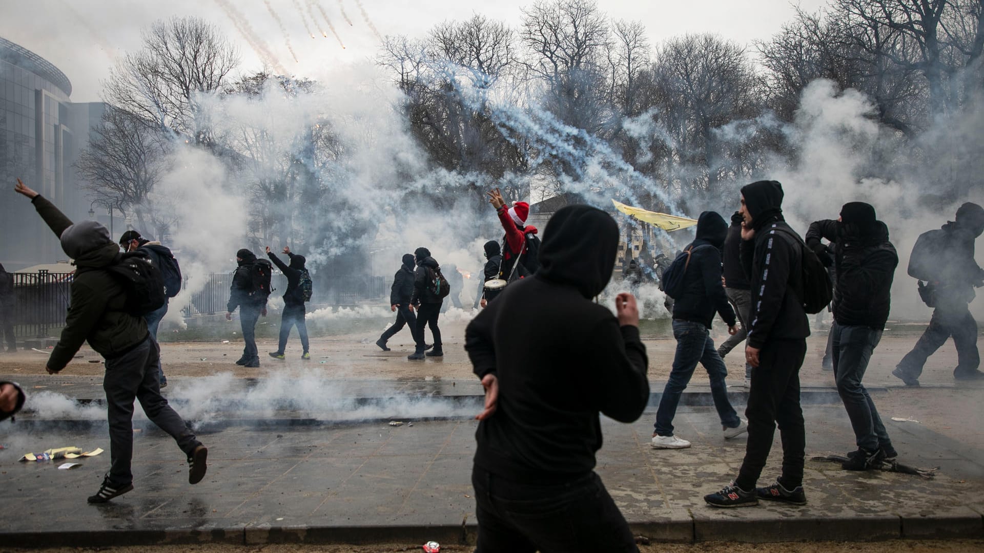 Proteste in Brüssel: Demonstranten stehen bei Zusammenstößen mit der Polizei inmitten von Tränengas. Proteste in Brüssel: Demonstranten stehen bei Zusammenstößen mit der Polizei inmitten von Tränengas.