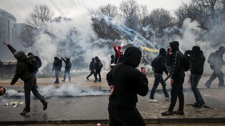 Proteste in Brüssel: Demonstranten stehen bei Zusammenstößen mit der Polizei inmitten von Tränengas.