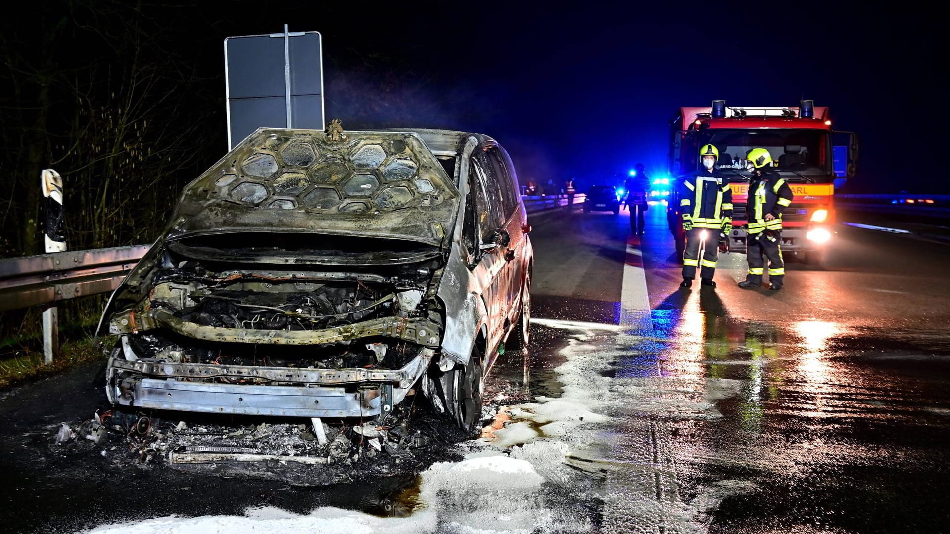 Ausgebrannter Pkw auf der A43: Die Insassen des Wagens konnten sich hinter eine Leitplanke retten.