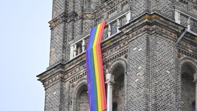 Eine Regenbogenfahne schmückt eine Pfarrkirche (Symbolbild): 125 Mitarbeitende der Katholischen Kirche hatten sich der Aktion angeschlossen.